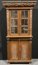 An early 20th century oak library bookcase, carved throughout in the 17th century manner, 206.5cm