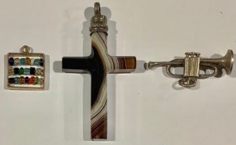 A 9ct gold charm, as an abacus; an agate crucifix; a silver coloured metal charm, as a trumpet (3)