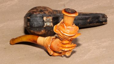A late 19th century meerschaum pipe, carved as a hand holding a rose, 11cm long, cased