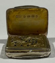 A Victorian silver rounded rectangular vinaigrette, engraved with scrolling leaves, gilt interior