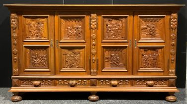 A large Continental oak enclosed bookcase or side cabinet, oversailing rectangular top above two