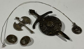 An Arts and Crafts silver pendant and earrings; a large dagger and shield silver brooch; an axe