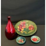 A Moorcroft hibiscus pattern bowl, 25cm diameter, mark on base; two trinket dishes; an ovoid Doulton