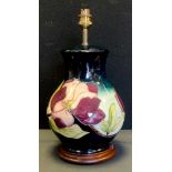 A Moorcroft 'wine magnolia' vase ovoid lamp, decorated with tube lined flowers and foliage, c.