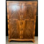 A mid century reproduction mahogany wardrobe, pair of doors enclosing five tiers of shelving to