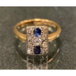 A sapphire and diamond ring, set with two oval blue sapphires and nine old round cut diamonds,