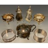 A four piece silver condiment set, two pepperettes, two salts; a silver mustard; two silver napkin