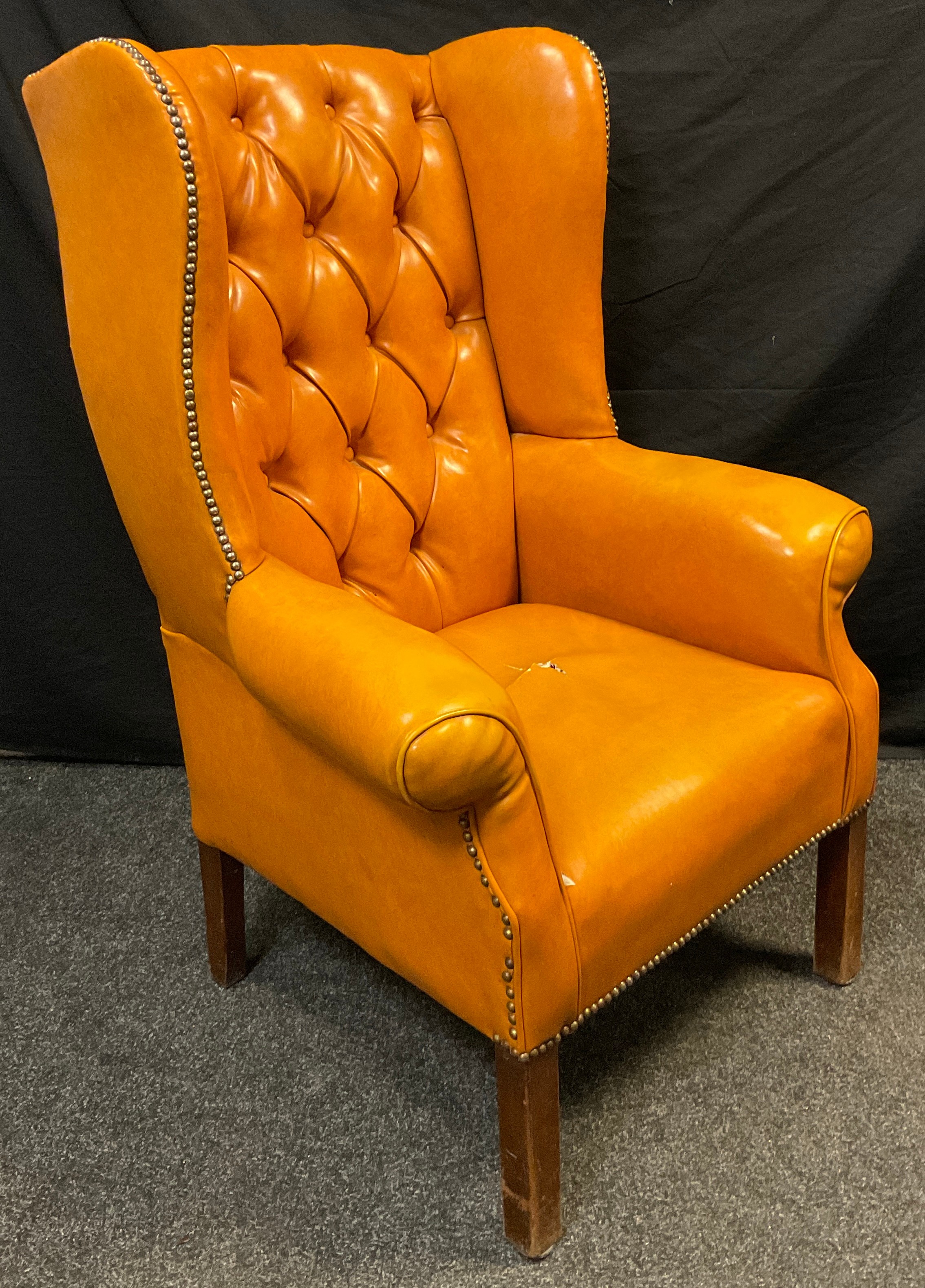 A Chesterfield wing-back office armchair, button back, warm ochre leather, square legs, 110cm high x