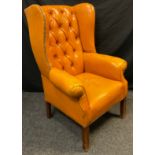 A Chesterfield wing-back office armchair, button back, warm ochre leather, square legs, 110cm high x