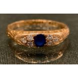 A sapphire and diamond ring, central blue sapphire flanked by six old brilliant cut diamonds, 18ct