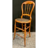 A late Victorian/Edwardian balloon back high chair, stuffed brown leather seat, turned legs, and