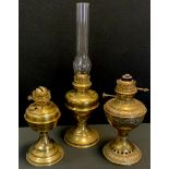A French brass oil lamp, embossed ornate body and reservoir, marked Lampe Veritas; others Belgian,