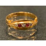 A diamond and ruby ring, alternate set with two pinky red rubies and three diamond dividers, 18ct