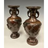A pair of Japanese Meiji period style bronze baluster-form vases, decorated in high relief with