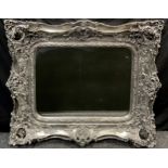 A large regency style wall mirror, rounded rectangular bevelled plate, silvered swept frame with