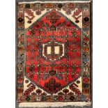 A Persian Hamadan ‘Prayer Mat’ type carpet or rug, knotted in tones of red, cream, pale blue, and