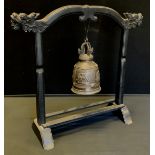 A Tibetan Archaic style ritual bell with ebonised dragon head stand.