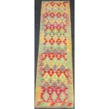 A Turkish Anatolian Kilim runner rug / carpet, geometric pattern in red, blue, and jade green, 290cm