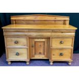 A Victorian pine sideboard, pediment shaped quarter galleried back with single narrow shelf,