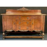 An early 20th century oak sideboard, quarter galleried back with carved cresting, over-sailing
