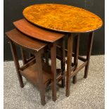 A nest of three walnut and mahogany tables, the largest with oval burr walnut top, 54cm high x