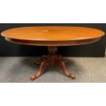 A George III style reproduction mahogany Loo Table, tilting oval top, turned pedestal base with four