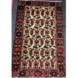 A Central Persian Bakhtiar rug / carpet, hand-knotted in deep red, indigo, and brown, on a cream