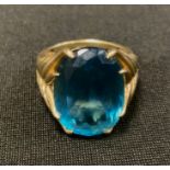 A vibrant blue stone oval dress ring, 9ct gold shank, stamped QVC 375, size O, 8.7g gross.