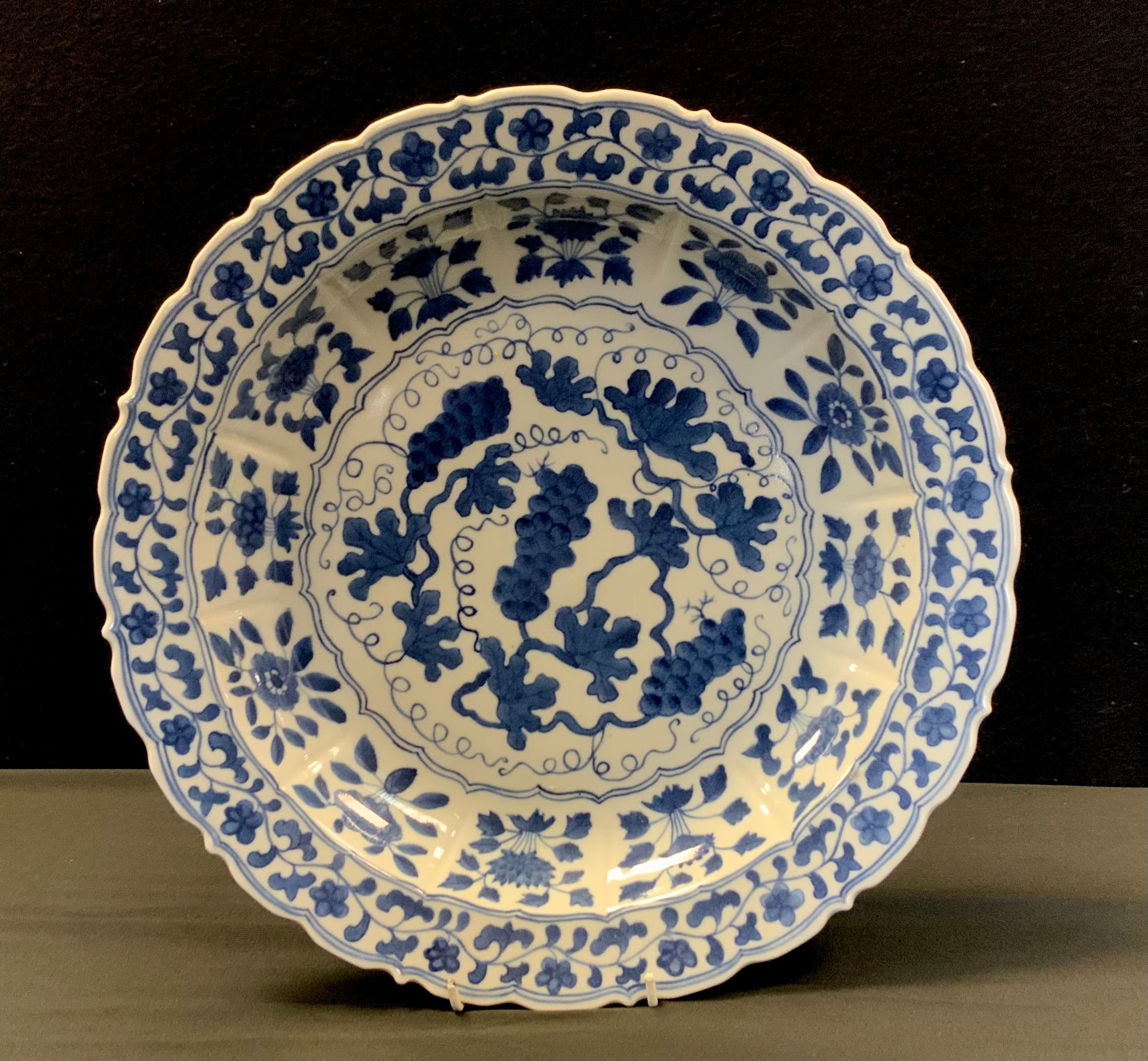 A Chinese porcelain blue and white shaped circular charger decorated with flowers and foliage,