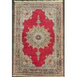 A Persian Isfahan style rug / carpet, lotus-form medallion within a red field, stylised floral