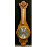 A German Carved oak aneroid barometer, and thermometer, 90cm high.