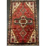 A North west Persian Heriz rug / carpet, hand-knotted in tones of red, deep blue, brown and cream,