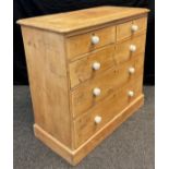 A pine chest of drawers, two short over three graduated long drawers, 96.5cm high x 102cm wide x