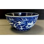 A modern Chinese blue and white bowl, decorated with Dragons amongst clouds,, deep blue and white