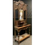 A Late Victorian oak hall stand, carved cresting and panels to top, central bevelled mirror with