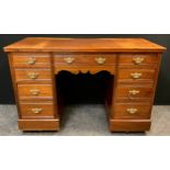 An early 20th century mahogany pedestal knee-hole desk, four graduated short drawers to each