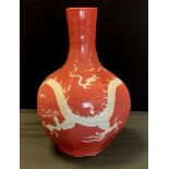 A Chinese octagonal baluster bottle vase, incised with a Dragon and the Pearl of Wisdom, pink