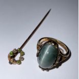 A 9ct gold polished agate dress ring, size G/H, 3.6g, boxed; a 15ct gold stick pin, set with green