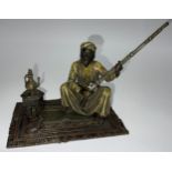 A Viennese cold painted bronze, of an Arab seated on carpet holding a rifle, 12cm high