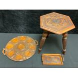 A chip carved stool, hexagonal top over three turned legs, 43cm high; a carved two handled