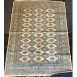 A Middle Eastern rectangular silk rug or carpet, geometric motifs in shades of green and cream,