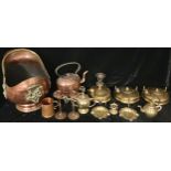 A copper cauldron shaped coal bucket, brass swing handle; a copper kettle on a pierced brass trivet;