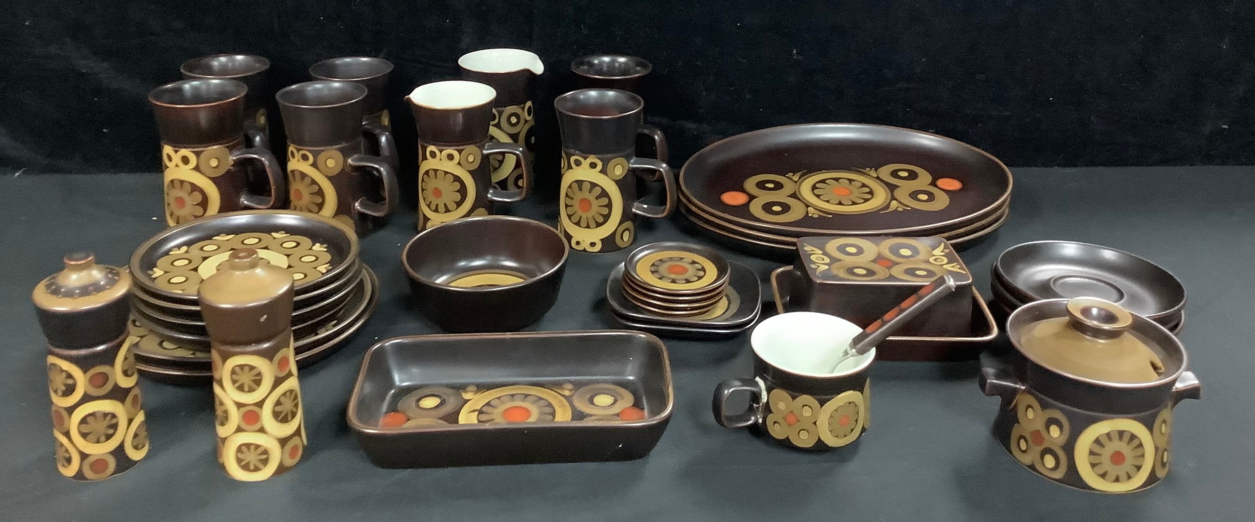 A set of six Denby Arabesque pattern tall coffee mugs, three oval plates, butter dish, preserve pot,