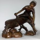 A reproduction bronzed figure, bare foot boy sat astride a log trout tickling, 24cm high