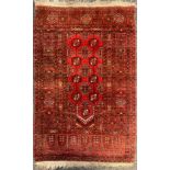 A Middle Eastern woollen rug or carpet, geometric motifs, in shades of red and black, 122cm x 76cm