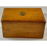 A late Victorian oak slope top stationery box, hinged cover applied with a brass plaque depicting