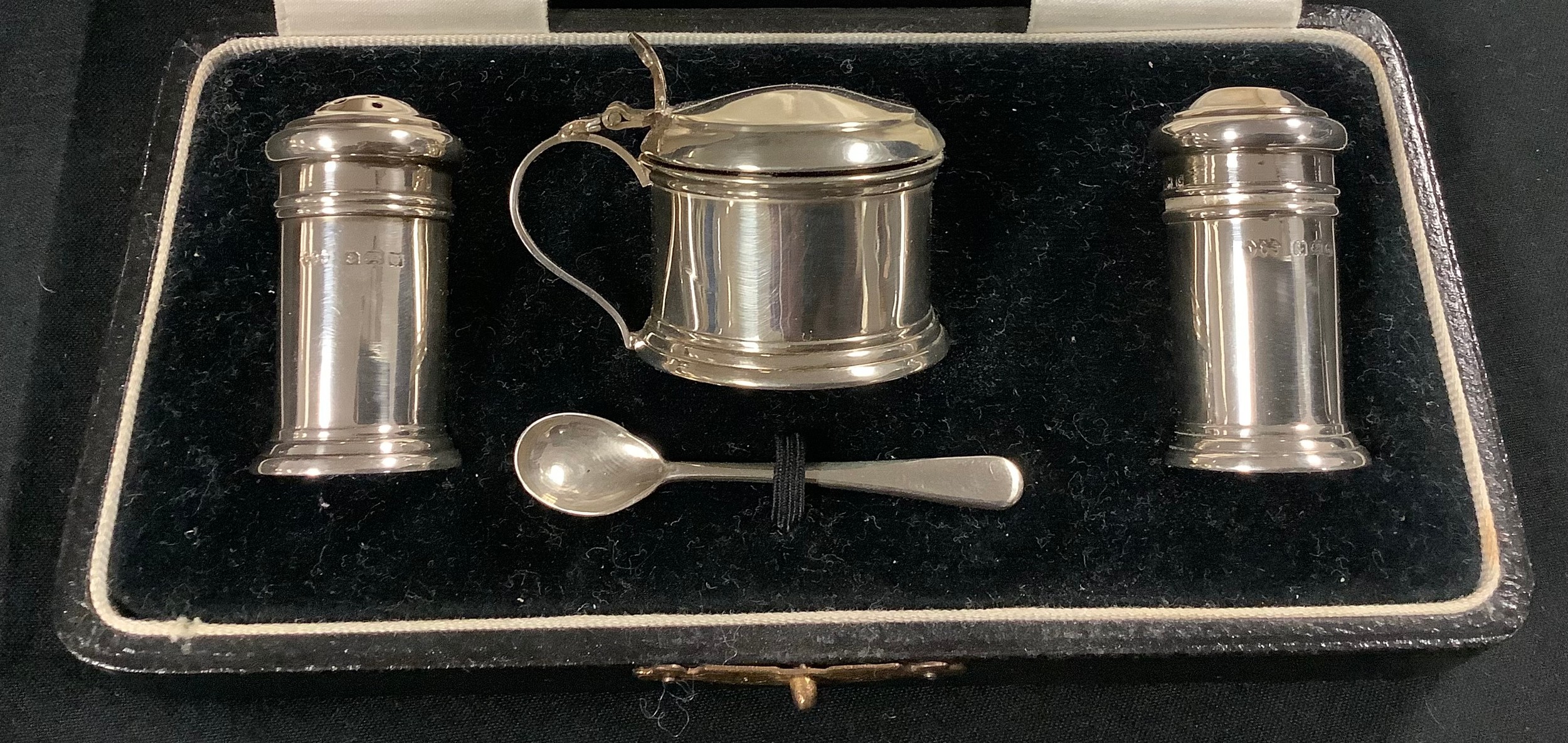 A George V silver three piece cruet set, salt pepper and mustard pot, with silver condiment spoon,