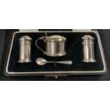 A George V silver three piece cruet set, salt pepper and mustard pot, with silver condiment spoon,