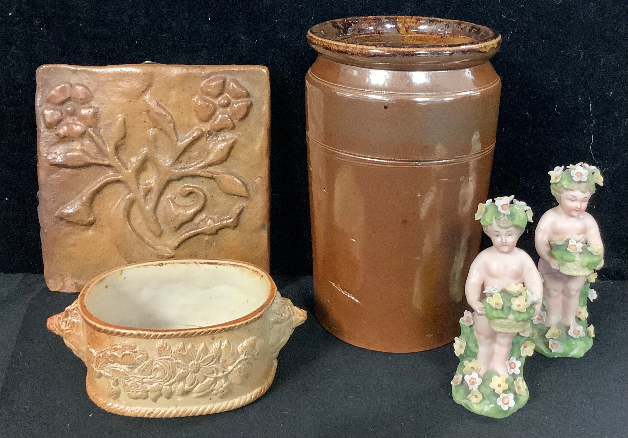 A Derbyshire salt glazed oval butter dish, lion mask handles, 14cm wide; a salt glazed jar and tile;