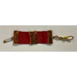 An Art Nouveau gold plated and red silk ribbon Albert or Albertina, 11.5cm long